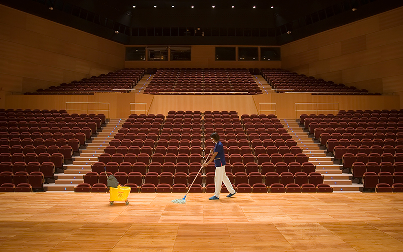 woman mopping auditorium stage